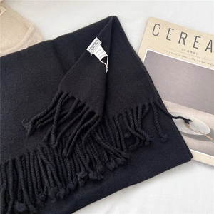 Detail of 100% wool scarf featuring dense tassels and thick premium knit texture