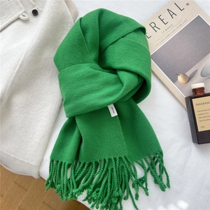 Detail of green 100% wool scarf showing high-quality twill weave texture and tassels