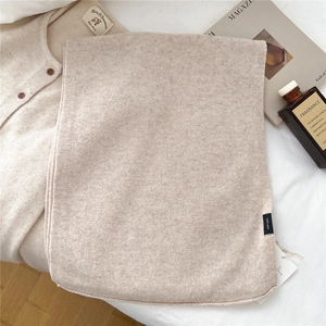 Detail of oatmeal knit wool scarf with 100% wool label and soft texture display