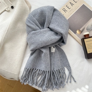 Detail of 100% pure wool scarf in gray with twill weave texture and elegant fringe
