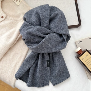 Detailed view of dark grey 100% wool scarf texture and material label for winter