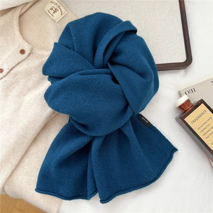 Detailed view of dark blue 100% wool knitted scarf with soft texture and premium finish