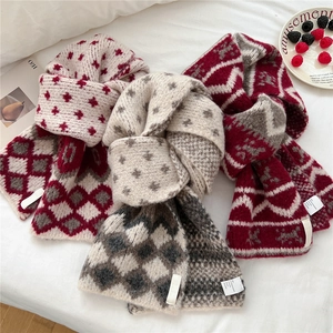 Three assorted winter knit scarves with star, plaid, and zigzag patterns in red and gray