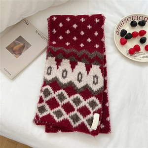 Close-up of thick wine red knit scarf with geometric patterns and soft texture
