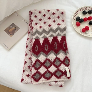 Detail of soft vintage knit scarf with Nordic geometric patterns in red and grey