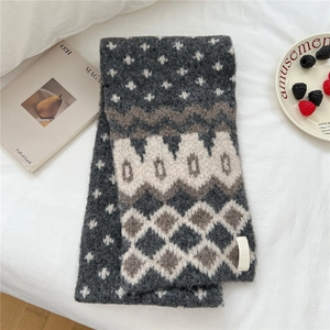 Detail of soft knit scarf with gray and brown snowflake patterns and thick texture