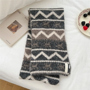 Close-up of geometric wave pattern knit scarf with thick texture and soft fringe