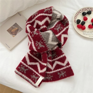 Detail of soft knit scarf with red and grey wavy pattern and small white brand label