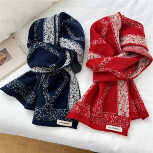 Navy and red knit scarves with geometric patterns on a white background bed