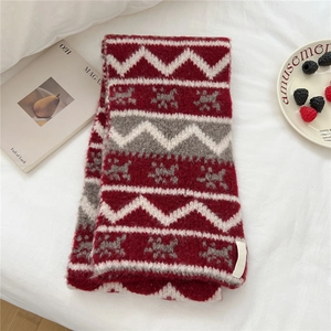 Detailed close-up of thick red knit scarf with Nordic snowflake and wave patterns