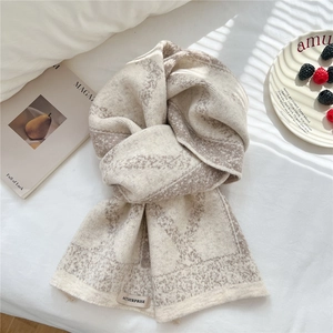 Detailed close-up of knitted rhombus pattern scarf with authentic woven brand label