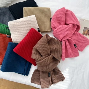 Stack of colorful 100% pure wool knitted scarves in diverse autumn and winter shades