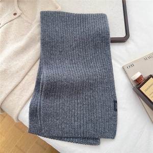 Detailed close-up of dark grey 100% wool scarf featuring a ribbed knit texture and soft fabric