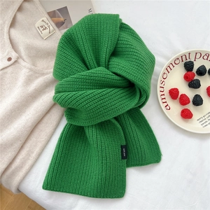 Detail of grass green 100% wool scarf featuring a thick ribbed knit texture for winter