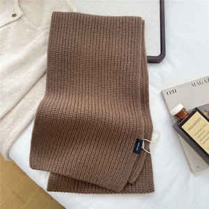Close-up of 100% wool label on solid brown ribbed knit scarf for winter fashion
