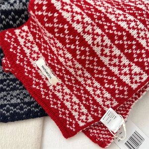 Close-up of 100% wool scarf with wave-patterned knit and product quality label