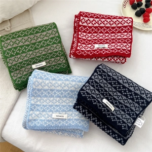 Collection of colorful 100% wool knitted scarves with heart patterns on white bedding