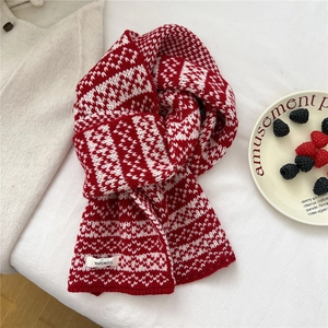 Detailed view of 100% wool knit scarf featuring red and white Nordic jacquard patterns