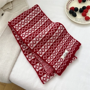 Close-up of red and white 100% wool scarf featuring thick wavy knit and fabric label