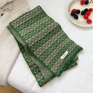 Detail of 100% wool knitted scarf with green and taupe wavy pattern texture