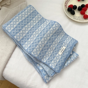 Detail of blue and white Fair Isle 100% wool scarf featuring a woven fabric composition tag