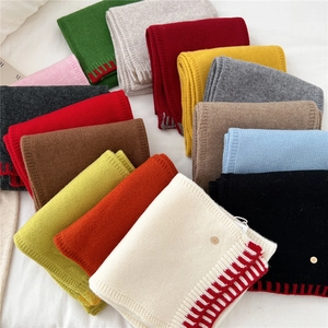 Two-tone wool knit scarves in multiple colors with striped edges and metal logo detail