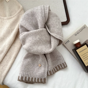 Detail of oatmeal knit wool scarf with dark brown ribbed hem and vintage D-button accent