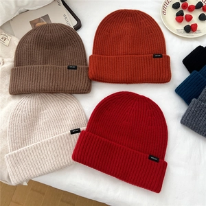 Assorted 100% wool knitted beanies in various warm colors for winter warmth