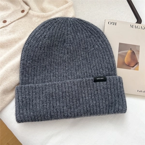 Close-up of dark grey 100% wool knit hat showing ribbed texture and quality wool label