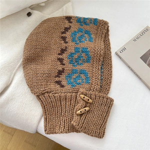 Detail of knitted balaclava with blue floral pattern and wooden toggle buttons
