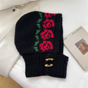Detail of knitted balaclava with red floral embroidery and wooden olive buttons
