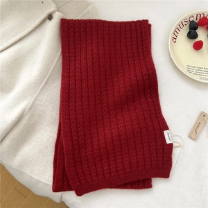 Dettaglio di sciarpa in maglia rossa spessa con trama a coste e etichetta logo