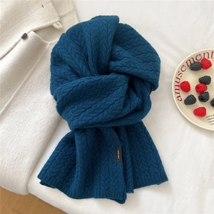 Detailed texture of dark blue 100% wool scarf with classic cable knit pattern