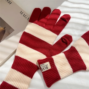 Detail of red and white striped knitted gloves with flip-top touchscreen finger caps