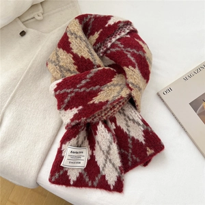 Close-up of geometric knit scarf texture with a woven label on thick warm fabric