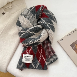 Detail of soft argyle knit scarf in red and grey with classic brand woven label