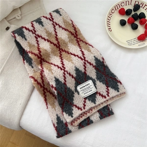 Detailed view of the thick argyle knit texture and fabric label on a warm winter scarf