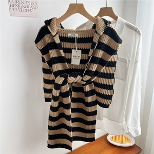 Detail of hooded knit shawl with black and yellow stripes featuring thick ribbed texture