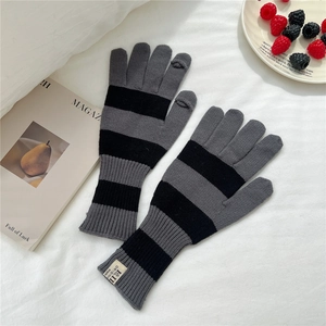 Detail of grey striped knitted gloves with touchscreen openings on finger tips