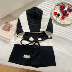 Close-up of black and white striped knitted balaclava with buttons and brand label detail