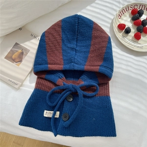 Detail of striped knitted balaclava hood featuring black buttons and thick yarn texture