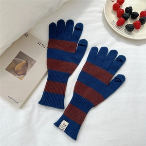 Close-up of striped knit gloves with touchscreen fingers and elastic ribbed cuffs