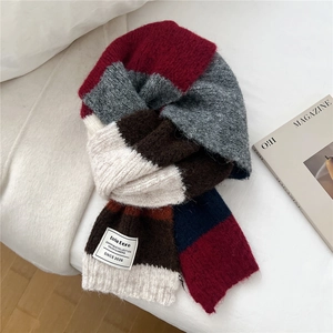 Gros plan d'une écharpe en maille à rayures colorées avec franges et patch de marque