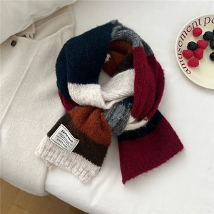 Gros plan détaillé d'une écharpe en tricot rayée avec étiquette de marque Doria Dore