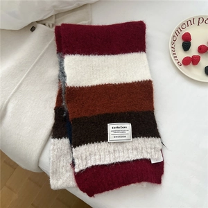 Détail de la texture de l'écharpe en tricot à rayures bicolores et étiquette décorative