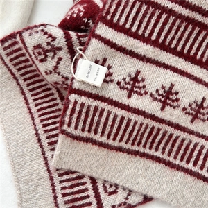 Detail of red and white wool blend scarf with Christmas tree pattern and knit texture