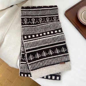 Close-up of thick jacquard knit wool scarf with geometric patterns and leather logo tag
