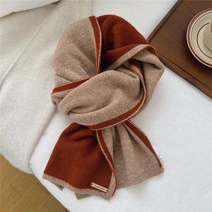 Detailed close-up of dual-tone wool scarf knitting texture and elegant brand logo tag