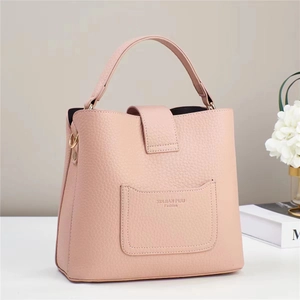 Detail of pink lychee grain leather bucket bag with top handle and embossed front pocket