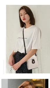 Détail d'un sac à bandoulière en cuir grainé avec rabat contrasté et bouton pression